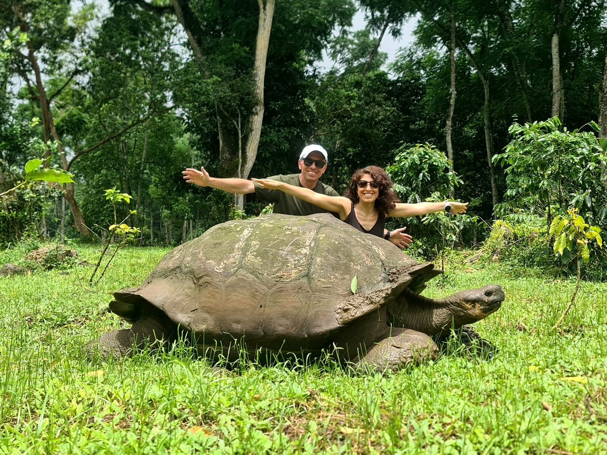 Reisende mit Riesenschildkröte auf Galápagos